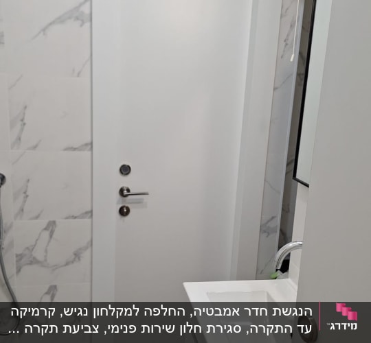 חדר אמבטיה משופץ עם כיור ודלת לבנה